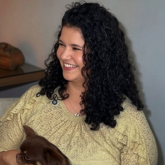 Dra. Adrielle Souza sorrindo, com um cachorrinho no colo