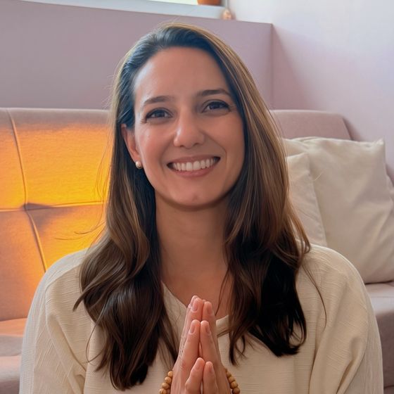 Dra. Ana Guimarães sorrindo, com as mãos unidas em frente ao peito segurando um japamala