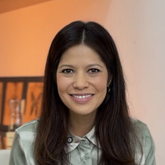 Dra. Juliana Yumi sorrindo, de camisa verde-clara